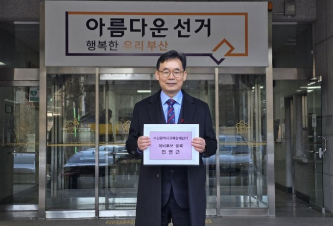 전영근 전 부산교육청 국장이 23일 예비후보 등록에 앞서 부산시선관위 앞에서 기념촬영을 하고 있다./사진=전영근예비후보측
