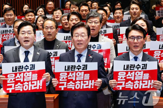 이재명 더불어민주당 대표와 박찬대 원내대표를 비롯한 의원들이 23일 오후 서울 여의도 국회에서 열린 의원총회에서 '내란수괴 윤석열을 구속하라'라고 적힌 피켓을 든 채 구호를 외치고 있다. 2024.12.23/뉴스1 ⓒ News1 안은나 기자