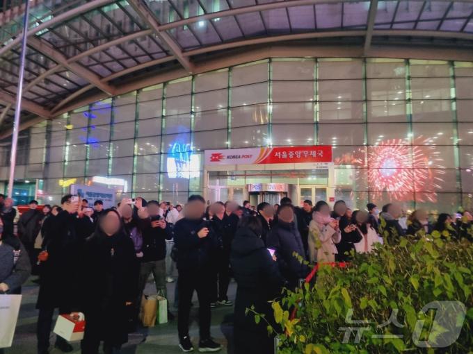 24일 저녁 서울중앙우체국 앞에는 신세계백화점 미디어파사드를 구경하기 위해 수백 명 인파가 몰렸다. / 뉴스1 박혜연 기자