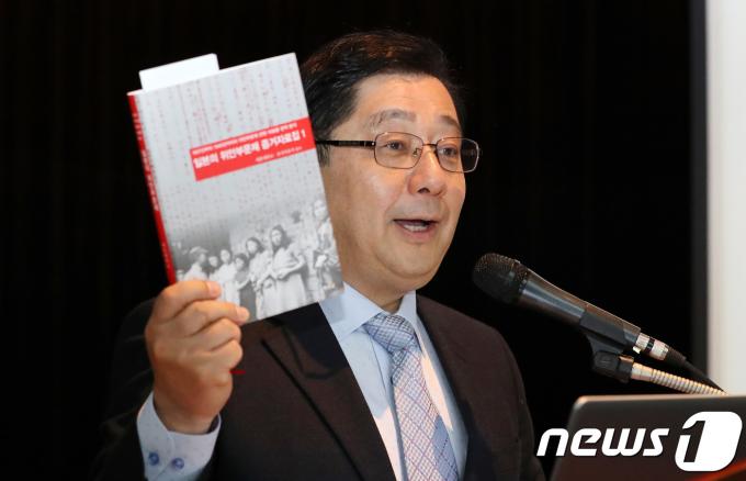 호사카 유지 세종대학교 일본학 교수가 10일 오전 서울 광진구 세종대학교 광개토관에서 열린 '일본의 위안부문제 증거자료집1' 출판 기념 기자 간담회에서 위안부 관련 문서를 공개하며 책을 들어보이고 있다. 2018.4.10/뉴스1 ⓒ News1 박지수 기자