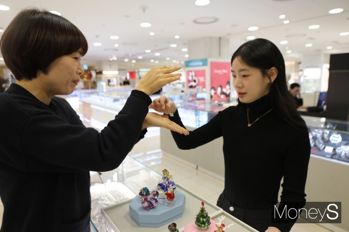 롯데백화점 광주점 2층 스와로브스키 매장 직원이 여성 손님에게 신상 쥬얼리를 선보이고 있다/사진=롯데백화점 홍보 3팀 제공.