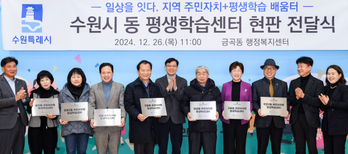 수원시 관계자가 26일 금곡동 행정복지센터에서 평생학습센터 제막식을 열고 시범운영 동에 현판을 전달하고 있다.  