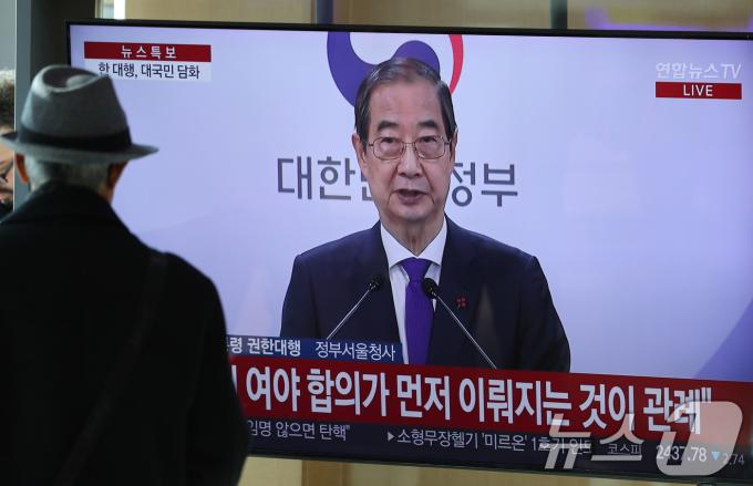 시민들이 26일 서울역 대합실에서 한덕수 대통령 권한대행 국무총리의 대국민 담화를 시청하고 있다. 한 권한대행 이날 대국민 담화에서 