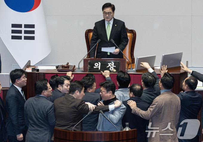 강명구 국민의힘 의원(오른쪽)과 김용만 더불어민주당 의원이 27일 오후 서울 여의도 국회 본회의장에서 열린 제420회 국회(임시회) 제2차 본회의에서 한덕수 대통령 권한대행 국무총리 탄핵소추안 탄핵 의결 정족수 과반 151명이라고 밝히자 다툼을 벌이고 있다. 2024.12.27/뉴스1 ⓒ News1 이재명 기자