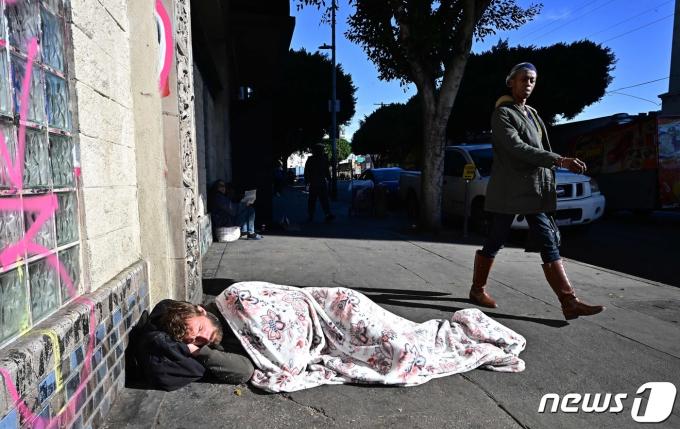 한 노숙자가 22일(현지시간) 미국 로스 앤젤레스의 도로 위에서 잠을 자고 있다. 2023.11.23 ⓒ AFP=뉴스1 ⓒ News1 정지윤 기자