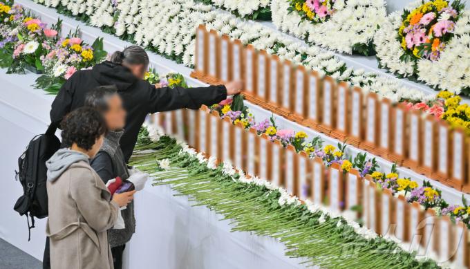 30일 오후 전남 무안군 무안종합스포츠파크에 마련된 제주항공 여객기 사고 희생자 합동분향소에서 한 조문객이 희생자의 명패를 어루만지고 있다. (공동취재) /뉴스1 ⓒ News1 김민지 기자