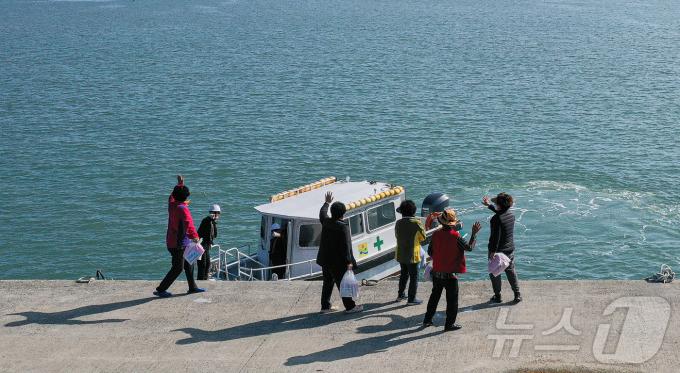 수송선에서 내린 섬마을 주민들이 직원들을 향해 인사하고 있다. ⓒ News1 이재명 기자
