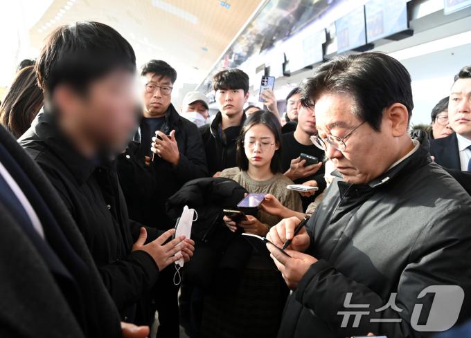 이재명 더불어민주당 대표가 31일 오전 전남 무안군 무안국제공항 터미널을 찾아 제주항공 여객기 사고 희생자 유가족을 위로하며 요구사항을 수첩에 적고 있다. (공동취재) 2024.12.31/뉴스1 ⓒ News1 김성진 기자