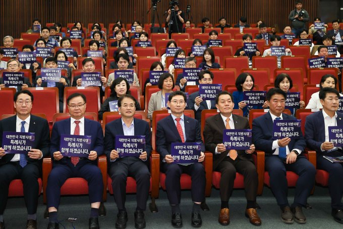 이상일 용인특례시장(앞줄 오른쪽으로부터 4번째)을 비롯한 특례시장들이 참석한 가운데 지난해 10월 국회도서관에서 열린 특례시 지원 특별법 제정을 위한 국회 정책토론회에서 손펫말을 들고 있다. / 사진제공=용인특례시