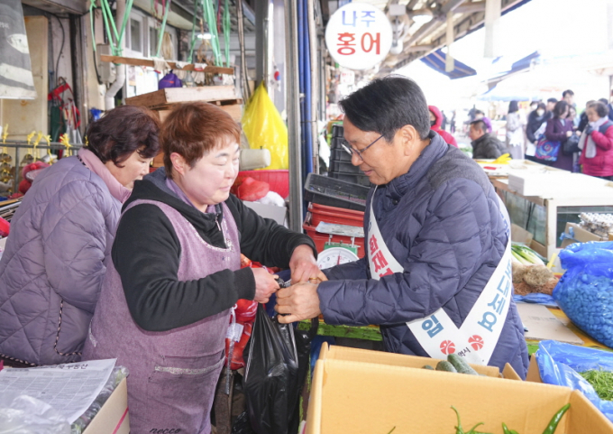 강기정 광주광역시장이 설명절을 앞두고 21일 광산구 송정매일시장을 찾아 상인들을 격려하며 전통시장 화재공제 가입 캠페인을 벌이고 있다./사진=광주시   