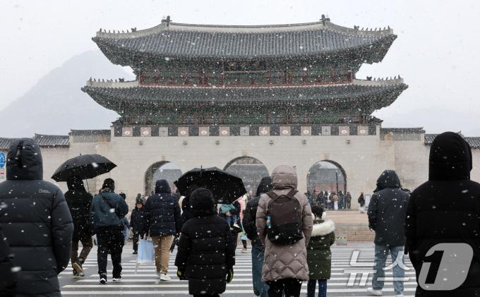 설 하루전인 28일 많은 눈이 내리고 있는 서울 광화문 앞 횡단보도에서 시민들이 발걸음을 옮기고 있다. 전국적으로 폭설이 내리고 있는 이날 경기남부와 충청·전북지역에는 대설경보가 발효됐다. 2025.1.28/뉴스1 ⓒ News1 박세연 기자