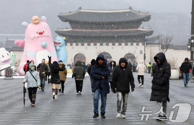 설 하루전인 28일 많은 눈이 내리고 있는 서울 광화문광장에서 외국인 관광객들이 발걸음을 옮기고 있다. 전국적으로 폭설이 내리고 있는 이날 경기남부와 충청·전북지역에는 대설경보가 발효됐다. 2025.1.28/뉴스1 ⓒ News1 박세연 기자