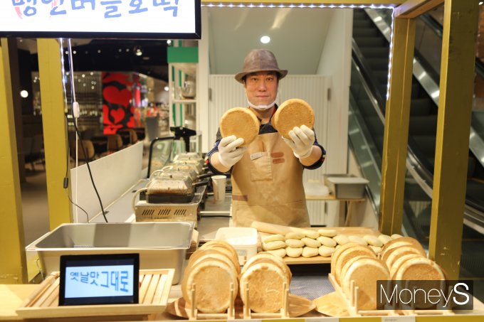 롯데백화점 지하1층 이벤트홀에서  옛날 호떡 맛을 재현한 '명품 버블호떡' 팝업 매장 관계자가 더블호떡을 들어보이고 있다/사진=롯데백화점 홍보 3팀 제공.