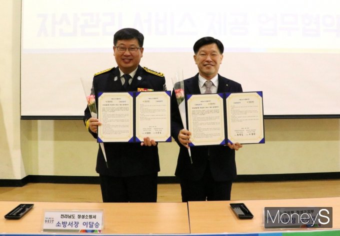 조상길 농협장성군지부장과 이달승 장성소방서장이 자산관리서비스 지원을 위한 업무협약을 체결하고 있다/사진=농협전남본부 제공.