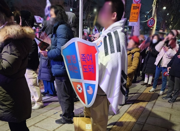 윤석열 대통령 탄핵심판이 마무리 절차에 들어간 가운데 일부 지지자들이 폭력적인 발언을 쏟아내고 있다. 사진은 지난 25일 서울 종로구 안국역 앞에서 윤석열 대통령 탄핵에 반대하는 한 지지자가 '빨갱이는 죽여도 돼'라고 적힌 방패를 든 모습. /사진=뉴스1