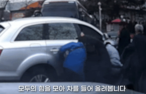 교통사고로 차에 깔린 피해자를 경찰, 시민들이 힘을 합쳐 구조했다. 사진은 경찰관과 힘을 합쳐 차를 들어 올리는 시민들의 모습. /사진=유튜브 채널 '대한민국 경찰청' 캡처