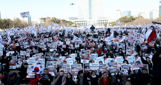 한국 민주주의 지수가 2023년도 보다 10단계 하락해 2024년 세계 32위를 기록했다. 사진은 지난 22일 대전시청 남문 광장에서 세이브코리아 주최로 열린 윤석열 대통령 탄핵 반대 집회에서 집회 참석자들이 태극기와 피켓을 흔드는 모습. /사진=뉴스1