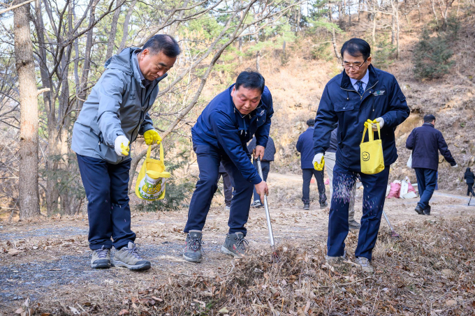 장충남 남해군수(가운데)와 간부공무원 등이 지난 27일 남면 임도에서 쓰레기 수거 후 꽃씨를 뿌리고 있다./사진=남해군