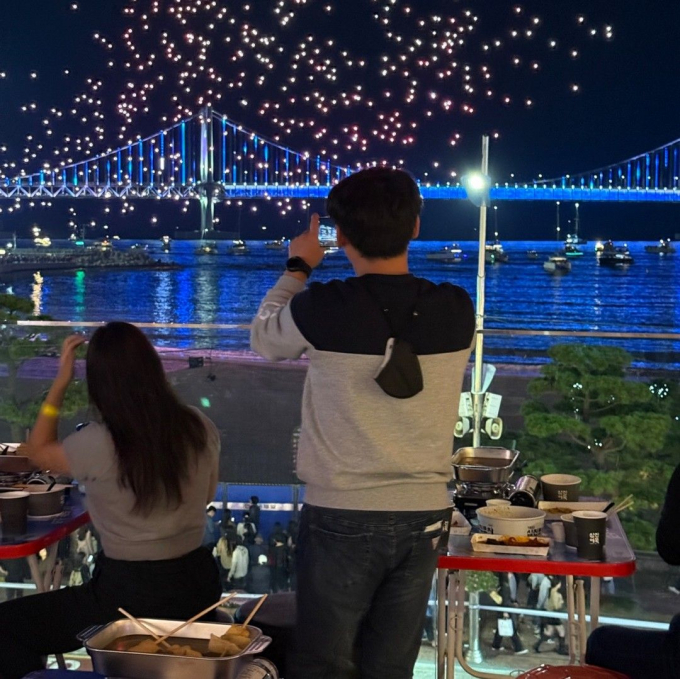삼진포차 고객들이 광안대교에서 열린 불꽃축제 장면을 촬영하고 있다./사진=삼진어묵