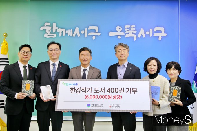 광주 서구청에서 6일 열린 한강 작가 도서 전달식에 김이강 서구청장(오른쪽 세번째)과 이동훈 광주신세계 대표이사(왼족 세번째)등 관계자들이 기념사진을 찍고 있다/사진=광주신세계 제공.