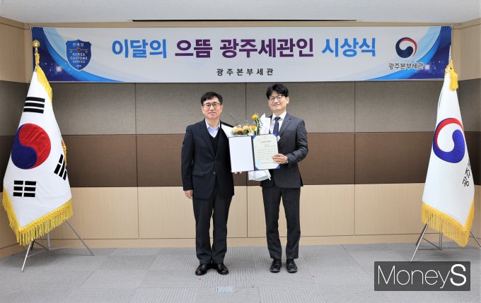 김동수 광주본부세관장이 '3월 으뜸 광주세관인'으로 선정된 김국현 주무관(오른쪽)과 기념사진을 찍고 있다/사진=광주본부세관 제공.
