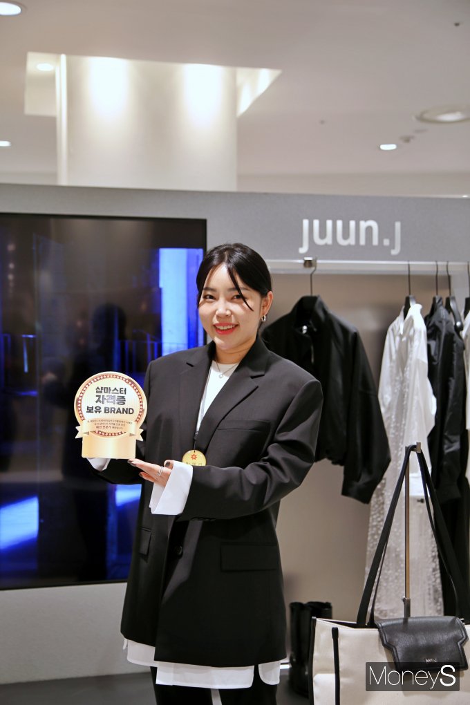 광주신세계 본관 4층 '준지' 매장에서 직원이 숍마스터 자격증 보유 브랜드 안내물을 선보이고 있다/사진=광주신세계 제공..
