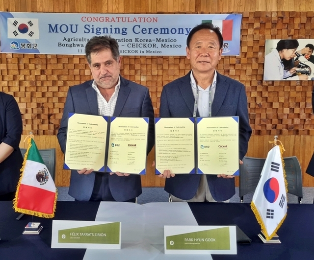 박현국 봉화군수(오른쪽)와 펠릭스 타라츠 세이코 농업대학장(왼쪽)이 업무협약을 체결한 뒤 협약서를 들어보이고 있다./사진제공=경북 봉화군