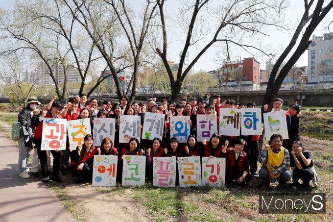 광주신세계 임직원들이 26일 광주천변 일대에서 에코 플로깅 활동을 펼친 뒤 기념사진을 찍고 있다/사진=광주신세계 제공.