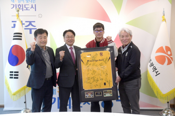 강기정 광주광역시장이 14일 오후 시청 접견실에서 광주FC 선수들의 선전 의지를 담은 선수단 사인 유니폼 액자를 이정효 감독으로부터 전달받고 있다./사진=광주시