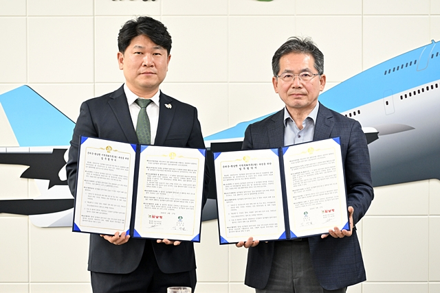 최진환 황남빵 대표이사(왼쪽)와 김진열 군위군수(오른쪽)이 업무협약서를 들어보이고 있다./사진제공=대구 군위군