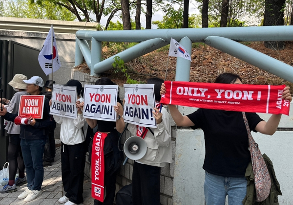 윤석열 전 대통령의 두 번째 형사재판이 열린 가운데 법원과 사저 앞에 모인 지지자들이 응원의 목소리를 높였다. 사진은 21일 오전 법원 입구에서 윤석열 전 대통령 지지자들이 응원하는 모습. /사진=뉴스1