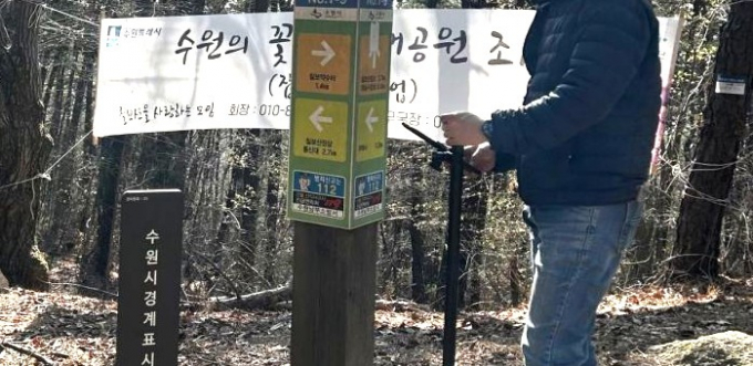 수원시 관계자가 GNSS를 활용해 칠보산 인근에 설치된 안내시설물의 위치정보를 측정하는 모습.
