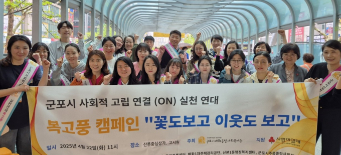 군포시 복고풍 회원 30여 명이 지난 22일 산본역 부근에서 고독사 예방 캠페인을 벌이고 기념촬영을 하고 있다. /사진제공=군포시 