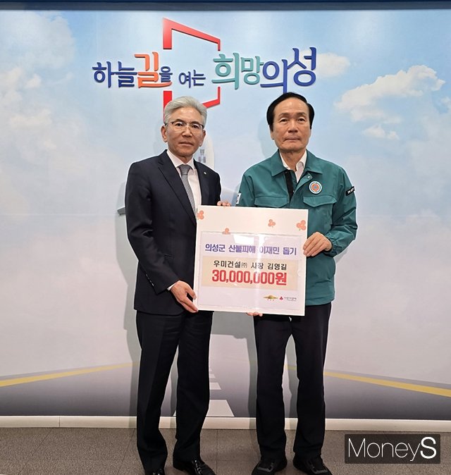 김영길 우미건설 사장(왼쪽)이 김주수 의성군수(오른쪽)에 성금을 전달하고 있다./사진=황재윤 기자