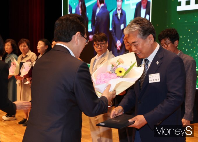 송남수 새마을운동무안군협의회 부회장(오른쪽)이 28일 도청 김대중강당에서 열린 제15회 새마을의 날 기념식서 지역발전에 헌신한 공로로 김영록 전남도지사로부터 유공표창을 받고 있다./홍기철기자