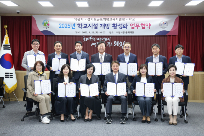 김성제 의왕시장(뒷줄 오른쪽서 4번째)이 군포의왕교육지원청 및 관내 14개 초중고등학교 관계자와 지난 29일 시청 중회의실에서 학교시설 개방 활성화 업무 협약을 체결하고 협약서를 들고 사진촬영을 하고 있다. /사진제공=의왕시 