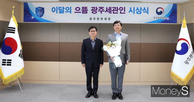 김동수 광주본부세관장(왼쪽)은 8일 '5월 으뜸 광주세관인'으로 선정된 오도형 주무관과 기념촬영을 하고 있다. /사진제공=광주본부세관 