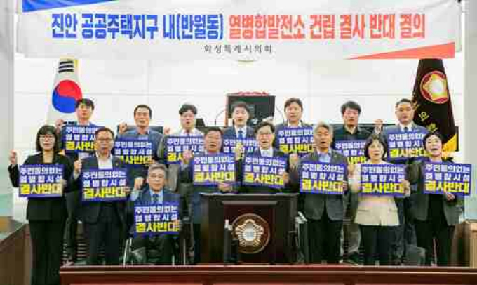 이해남·오문섭 화성시의원 등 15명이 8일 진안 공동주택지구 내 열병합발전소 건립 계획과 관련해 지역사회에 미칠 영향에 대해 심각한 우려를 표명하며, 신중한 재고를 촉구하는 결의문 채택 후 손펫말을 들고 구호를 외치고 있다. /사진제공=화성시의회