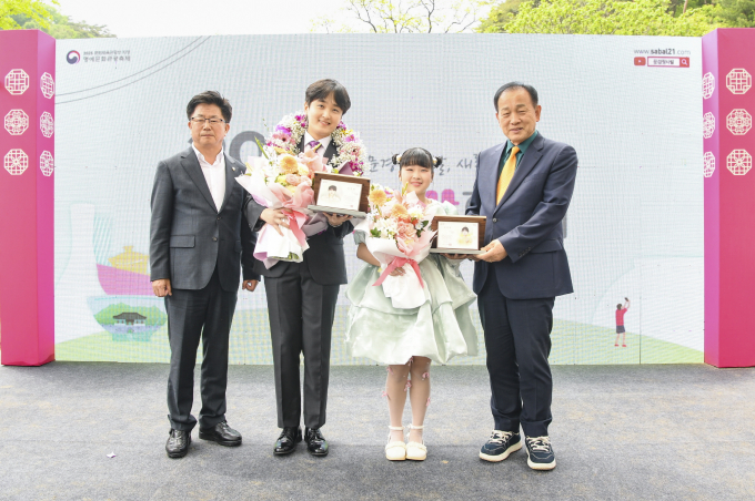 문경시가 트롯 유망주 이재희 군(왼쪽에서 두번째)과 장혜진 양(오른쪽)에게 위촉패를 수여하고 있다./사진제공=경북 문경시