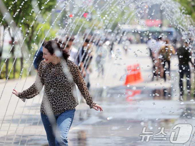 대체로 맑고 포근한 '초여름 날씨'를 보인 12일 오후 서울 광화문광장 분수터널에서 외국인 관광객들이 더위를 식히고 있다. 2025.5.12/뉴스1 ⓒ News1 황기선 기자