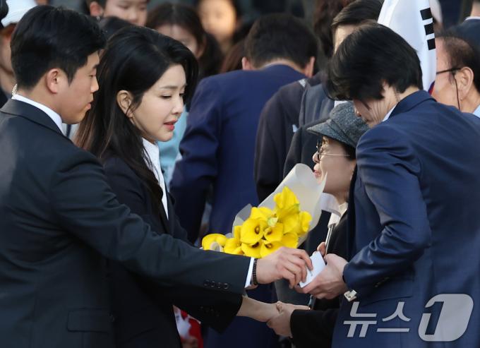 김건희 여사가 지난달 11일 서울 서초구 아크로비스타 사저로 향하며 꽃다발을 선물받고 있다. (공동취재)/뉴스1 ⓒ News1 박세연 기자