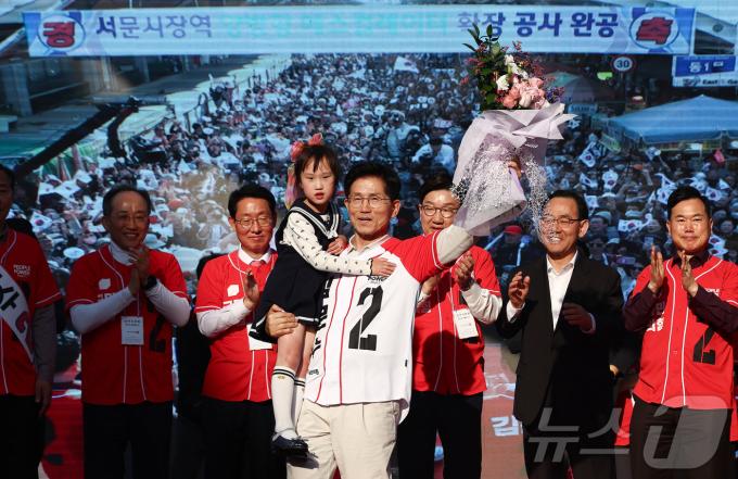 제21대 대통령 선거 공식 선거운동 첫날인 12일 김문수 국민의힘 대통령 후보가 대구 중구 서문시장에서 유세도중 어린이와 손을 들어보이고 있다. 2025.5.12/뉴스1 ⓒ News1 김민지 기자