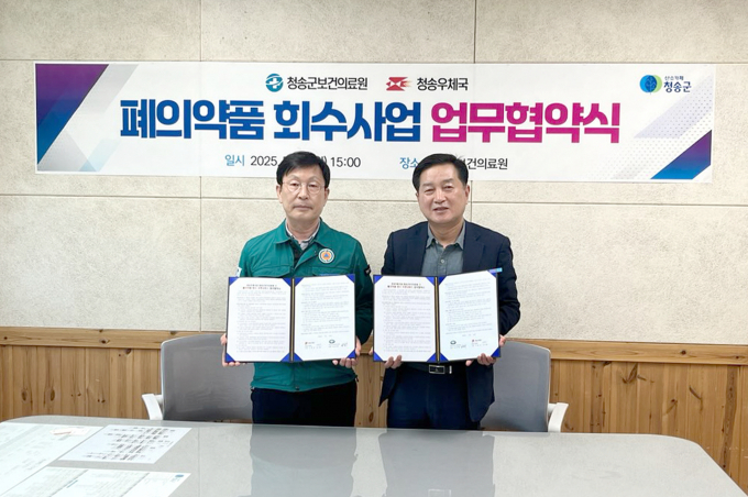  청송군이 청송우체국과 '우편서비스 기반 폐의약품 회수 시스템 구축'을 위한 업무협약서를 들어보이고 있다./사진제공=경북 청송군