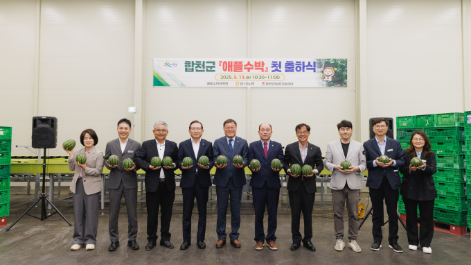 김윤철 합천군수(왼쪽 다섯번쨰)와 정봉훈 군의장(왼쪽 여섯번째), 애플수박 생산자 등 관계자들이 애플수박 첫 출하식에서 기념촬영을 하고 있다./사진=합천군