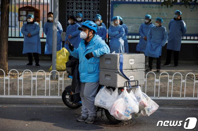 23일 중국 베이징에서 신종 코로나바이러스 감염증(코로나19) 확산이 계속됨에 따라 음식 배달원이 봉쇄된 주거 단지 밖에서 기다리고 있는 모습. 2022.11.23/뉴스1 ⓒ 로이터=뉴스1 ⓒ News1 김민수 기자