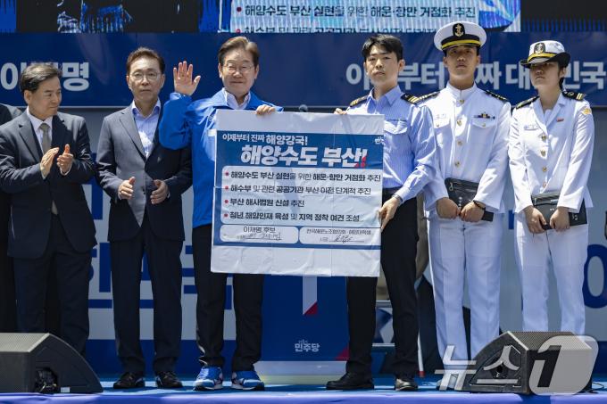 이재명 더불어민주당 대통령 후보가 민주당 험지로 꼽히는 부산·경남(PK) 지역 유세에 나선 14일 부산 부산진구 서면에서 권기흥 에이치라인해운해상직원노조 위원장과 해양수도 부산 협약서에 서명한 뒤 기념 촬영하고 있다. (공동취재) 2025.5.14/뉴스1 ⓒ News1 안은나 기자