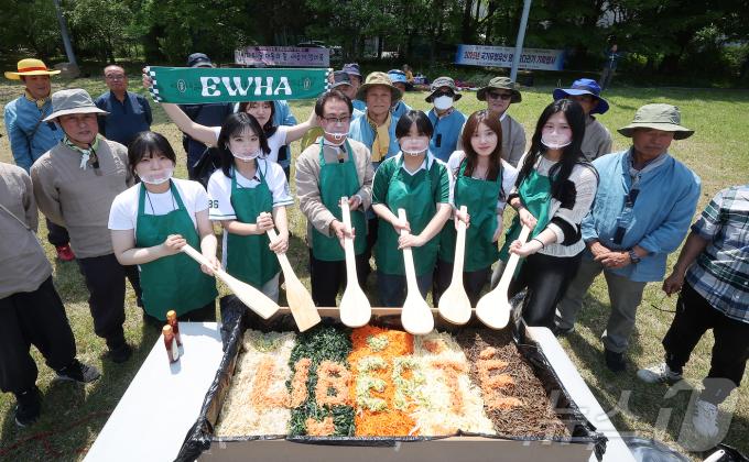139주년 대동제가 열리는 14일 서울 서대문구 대현동 이화여자대학교 잔디광장에서 총학생회 임원들과 교직원들이 학생들에게 나눠줄 대형 비빔밥을 비비고 있다. 2025.5.14/뉴스1 ⓒ News1 김진환 기자