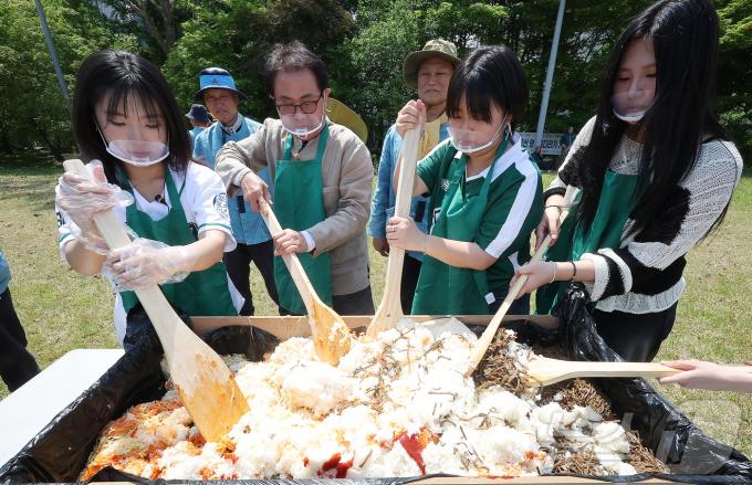139주년 대동제가 열리는 14일 서울 서대문구 대현동 이화여자대학교 잔디광장에서 총학생회 임원들과 교직원들이 학생들에게 나눠줄 대형 비빔밥을 비비고 있다. 2025.5.14/뉴스1 ⓒ News1 김진환 기자