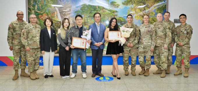 정장선 평택시장(왼쪽서 6번째)이 15일 지난 4월 팽성대교에서 발생한 투신 사고 현장에 출동한 소방대원들과 협력해 투신자 구조에 도움을 준 민경찬 씨(왼쪽서5번째)와 재니스 카르타헤나 보니야 씨(왼쪽서 7번째)에게 유공자 표창 수여하고 사진촬영을 하고 있다. /사진제공=평택시