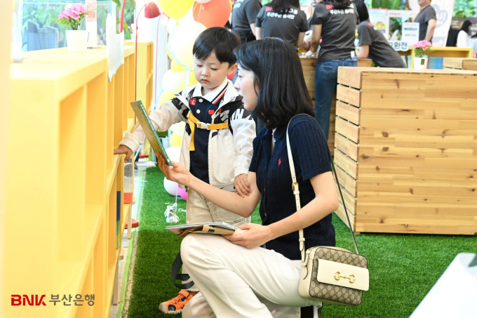 자녀와 함께 한 가족이 부산은행 도서교환전 행사에 참여하고 있다./사진=부산은행